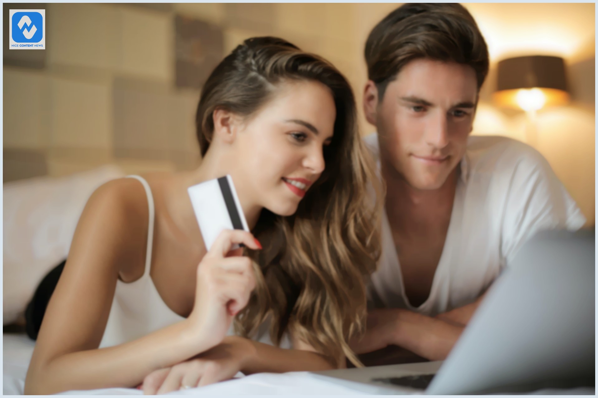 Um homem e uma mulher com um cartão de crédito na mão fazendo compra de roupa online