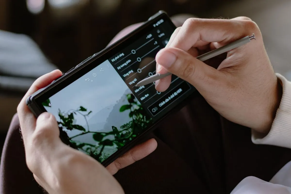 Mãos seguram um celular e ajustam uma foto em aplicativo de edição de imagem